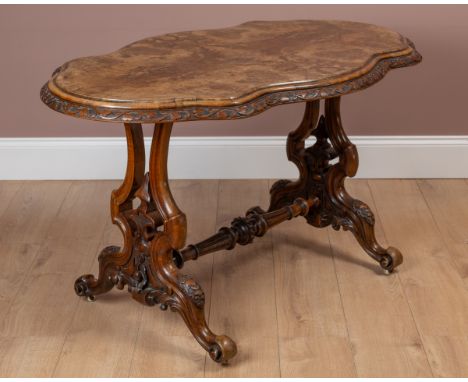 The shaped top with a relief carved clover moulding to the edge, raised on stylised baluster supports with cabriole legs term