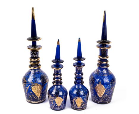With gilt highlighting and etched decoration, ring cuffed necks and steepled stoppers.First pair 50cm high; second pair 35cm 