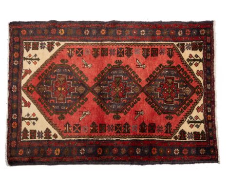 An opposed pair with three central medallions on a red ground; together with a third larger rug with a bar medallion on a dar