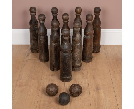 The ten turned wooden skittles with iron rings to their bases, complete with two iron-studded balls.Each skittle 46cm highQty