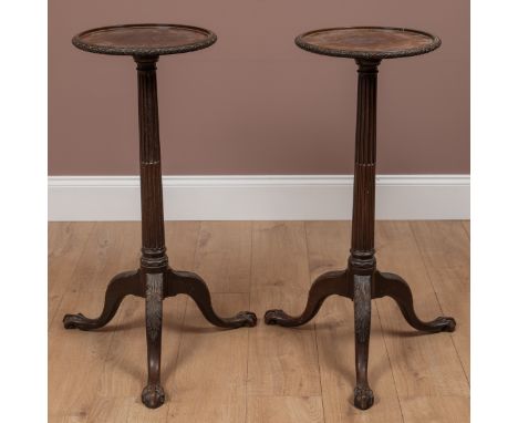 The circular tops with carved rims on reeded stems, raised on tripod claw and ball feet.37cm diameter x 88cm highQty: 2Some l