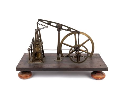 The brass steam engine with spoked flywheel and Watts parallel motion connecting the beam to the piston rod, all mounted on a