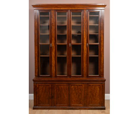 The top in an arrangement of three sections with a central double door with glazed panels, enclosed by two smaller doors with