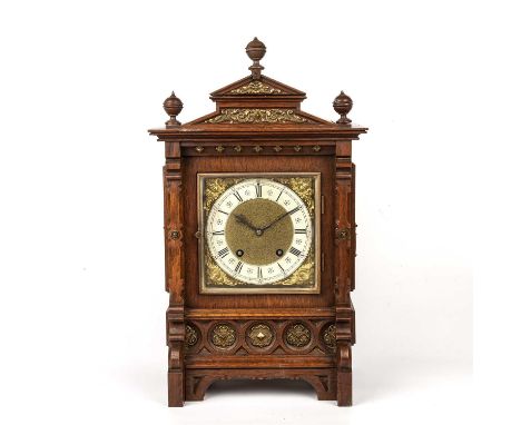 An early 20th century German mantel clock, the square brass dial with silvered Roman chapter ring, mask spandrels, and Lenzki