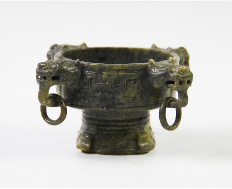 A Chinese Nephrite spinach jade censer, of circular form with four lions mask ring handles, carved with archaic forms, 13cm w