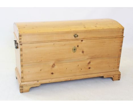 A Victorian dome top pine trunk, of tapering form with a fitted candle box, raised upon bracket feet and applied with iron sw