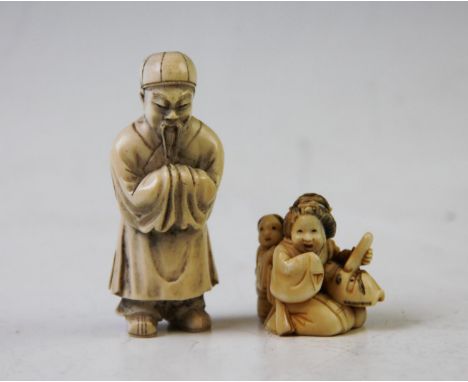 A late 19th century Japanese carved ivory netsuke, depicting a seated mother, flanked by a child, mark to base, 3.7cm high, w