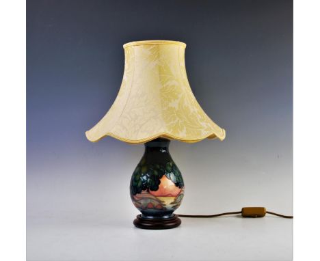A Moorcroft table lamp of baluster form, decorated with stylised balloon trees in a lakeland landscape, on turned wood base, 