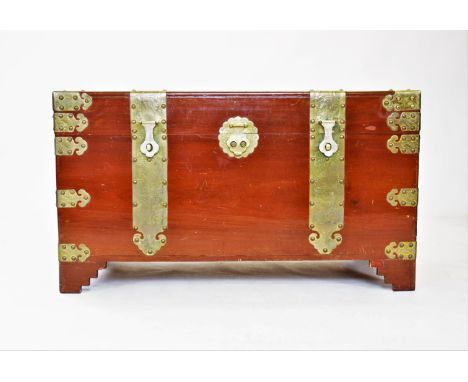 A 20th century Oriental camphor wood trunk, of rectangular form, with ornate brass fittings, decorated with dragons and folia