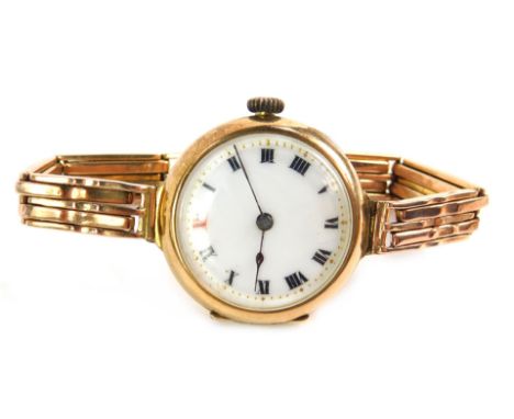 A lady's 9ct gold circular cased wristwatch, white enamel dial bearing Roman numerals, on a 9ct gold gate bracelet with snap 