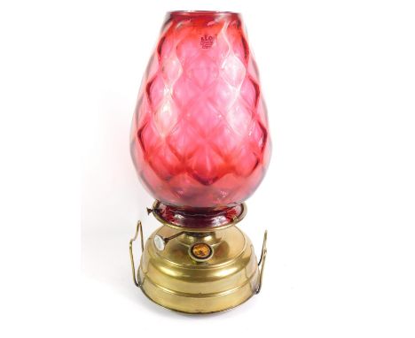A Continental brass oil lamp, with chimney and cranberry honeycomb glass shade, 49cm high.