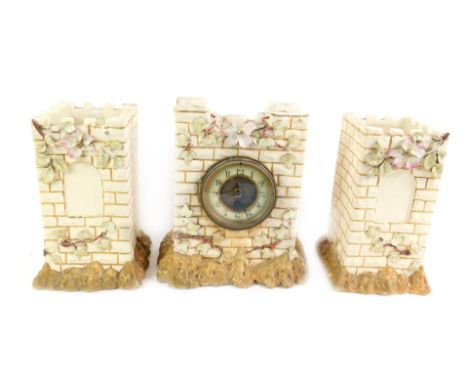 A late 19thC pottery clock garniture, of castle form encrusted with roses, the clock with brass dial and enamel chapter ring 