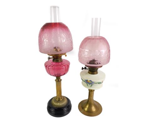 A Victorian fluted brass oil lamp, with a cranberry glass reservoir, with chimney, and etched clear to cranberry glass shade,