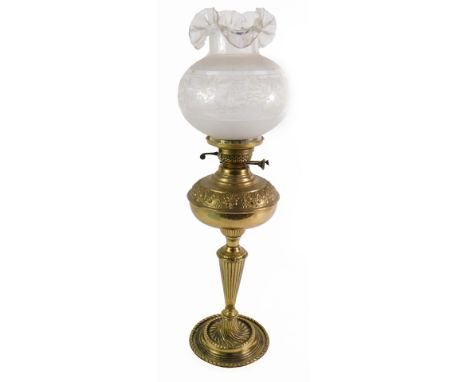 A Victorian brass oil lamp, with an embossed reservoir, raised on a fluted stem and circular base, with an etched clear glass