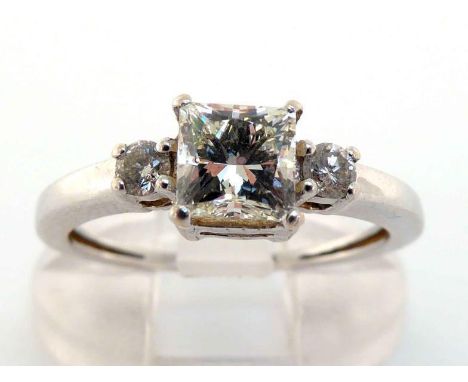 A diamond ring, the central princess cut stone approx. 0.87 carat, to small brilliant cut shoulders, the white shank stamped 