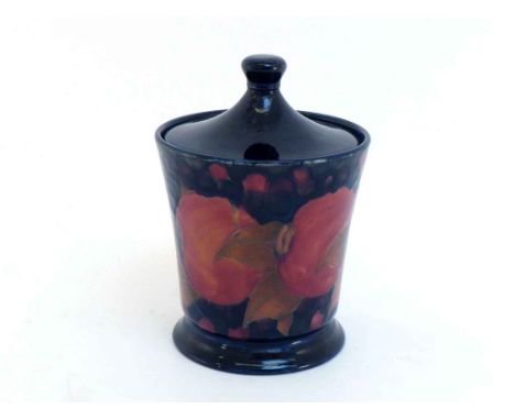 A Moorcroft ceramic tobacco jar in the Pomegranate pattern on a dark blue ground, circa 1915, the base with William Moorcroft
