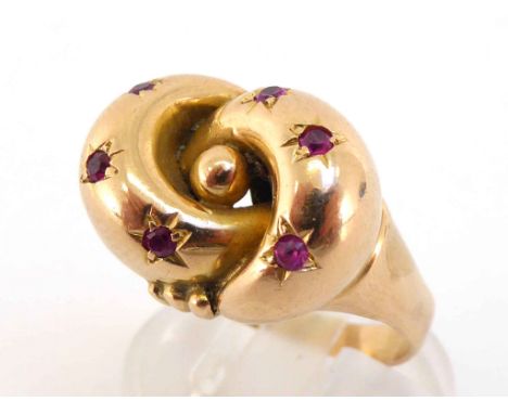 A Victorian gold and ruby knot ring, the central motif set with small round cuts, the shank marked '18ct', finger size R, 8.7