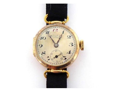 A 1920s lady's 14 carat gold manual wind wristwatch, the circular three piece case with stirrup lugs, signed silvered dial ('