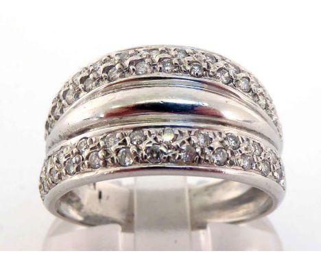 A diamond dress ring, the tapering bezel pave set top and bottom with two rows of small brilliants, mounted in white metal (t