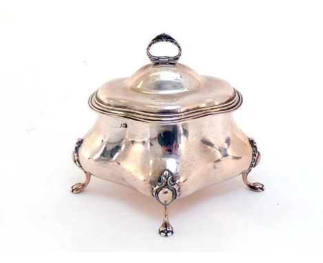 A silver tea caddy of oval quatrefoil form, marks indistinct,   Chester, 1915, the four claw feet terminating in cartouches, 