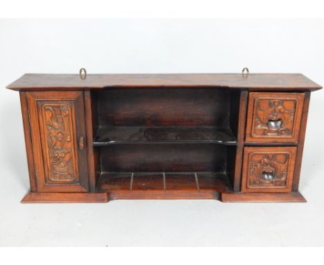 A 20th century Chinese hardwood cabinet, with central shelf flanked by a cupboard door and two drawers, carved with bats and 