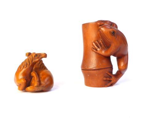 Wooden netsuke carved as two seated horses, signed to base, and a wooden carving of a frog on bamboo, signed. (2)