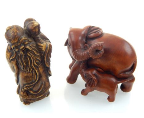 A Chinese stone carving of the God of Longevity Shou Xing, 7cm h, and a wooden carving of an elephant playing with her calf, 