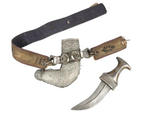 λ An Arabian dagger (jambiya), curved blade 6.5 in., silver mounted horn hilt with repousse collar and grip band; scabbard fa