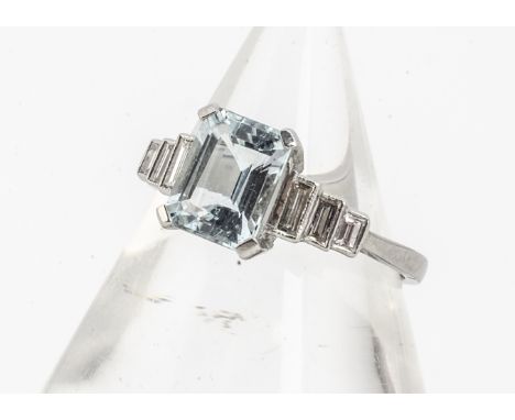An Art Deco style aquamarine and diamond dress ring, mixed step cut aquamarine with triple baguette cut diamond step shoulder