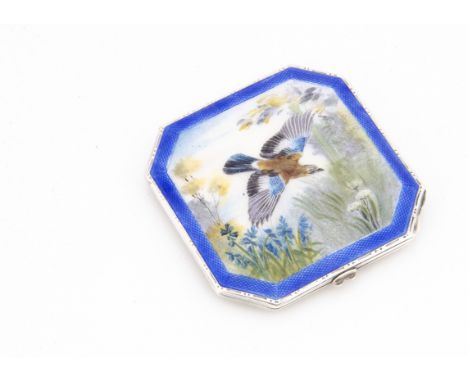 An Art Deco period silver and enamelled compact by NCD, having swooping jay amongst flowers to lid, octagonal and engine turn