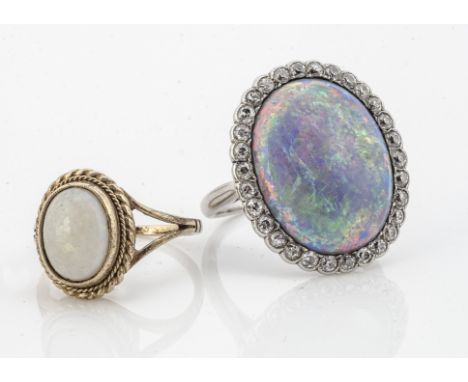 A large black opal and diamond bezel set dress ring, in white metal, the oval black opal with old cut diamonds, opal af to ba