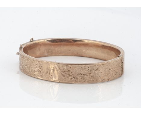 A 9ct gold hinged bangle, with engraved floral decoration, 6cm x 5.2cm internal measurement, 17.2g 