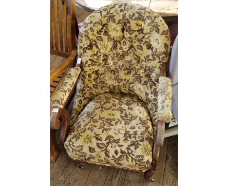 A Victorian floral upholstered button back armchair on brass castors