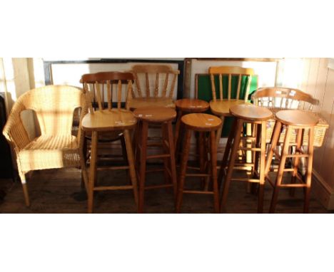 Five various pine bar stools and three bar chairs, a wicker picnic hamper with contents, a folding card table, a wicker armch