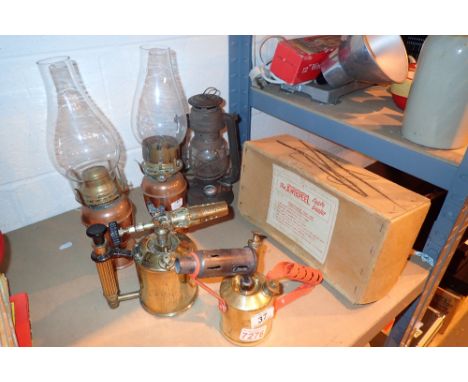 Pair of brass paint strippers and copper spirit lamps with a storm lamp and apple peeler