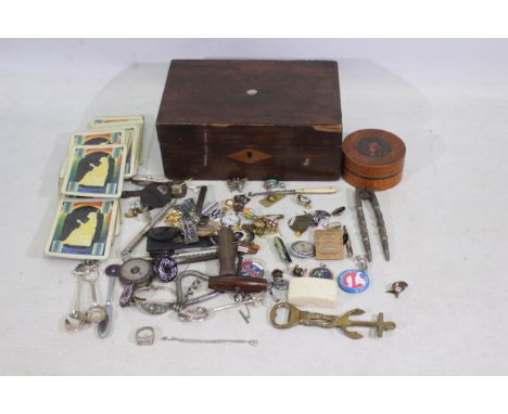 Wooden jewellery box containing silver plated spoons, enamel badges, brass bottle opener, and similar. Also includes a silver