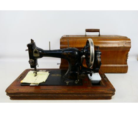 A vintage sewing machine in wooden case. [W]