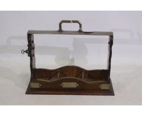 A wooden and metal tantalus for three glass decanters. Comes with key and when twisted the handle is able to fold down. Doesn