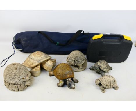 A collection of garden animal ornaments, predominantly tortoises, a small tool kit and a folding armchair. [2]. [W]