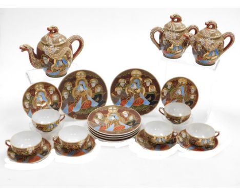 A Taisho period Japanese Kutani porcelain tea set, decorated with dragons in relief and reserves of figures, coral, red and b