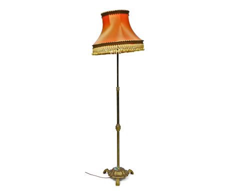 An early 20thC brass standard lamp, with a frill salmon pink coloured shade, 191cm high.