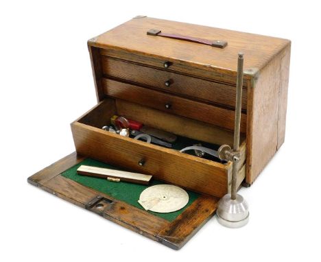An early 20thC oak tool chest, with a drop down front enclosing four graduated drawers with recess below, holding some tools,