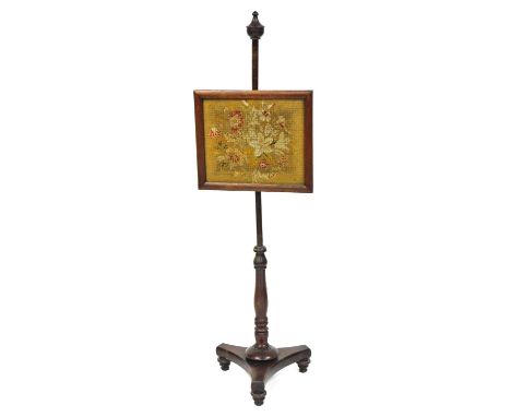 A late Regency mahogany pole screen, the rectangular screen with floral tapestry, raised on a turned column over a trefoil ba