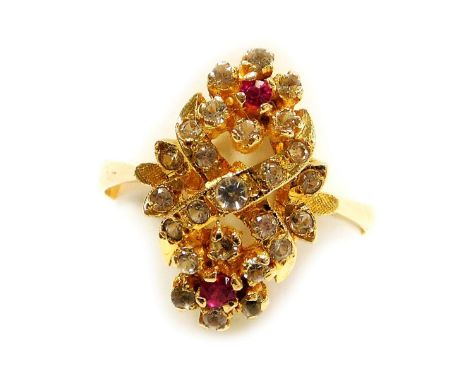 A ruby and white sapphire ring, in a double flower head and cross design, in a yellow metal high claw basket oval mount, stam