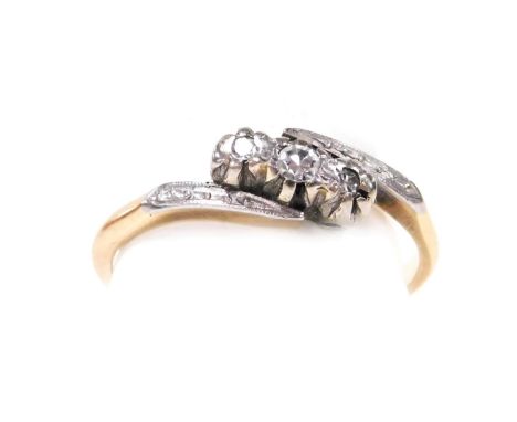 A 9ct gold platinum and diamond three stone ring, in a cross over setting, size O, 1.9g. 