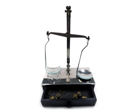 A set of early 20thC W &amp; T Avery Limited balance scales, raised on a metal topped wooden base, with frieze drawer contain