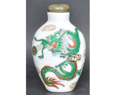 An early 20th century circa 1920s ceramic perfume bottle having polychrome detailing of a dragon with original green stone st