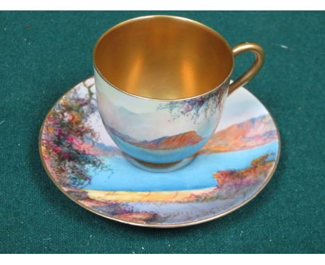 ROYAL WORCESTER HANDPAINTED AND GILDED CERAMIC CUP AND SAUCER DECORATED WITH A CONTINENTAL LAKE SCENE, SIGNED (INDISTINCT)
