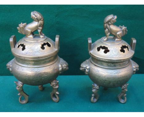 PAIR OF ORIENTAL BRONZE/BRASS INSENCE BURNERS WITH COVERS ON RAISED SUPPORTS DECORATED WITH ORIENTAL SCENE APPROX. 25cm HIGH 