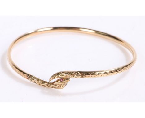 9 carat gold bangle in the form of a snake curled up with garnets for eyes, gross weight 6.0 grams